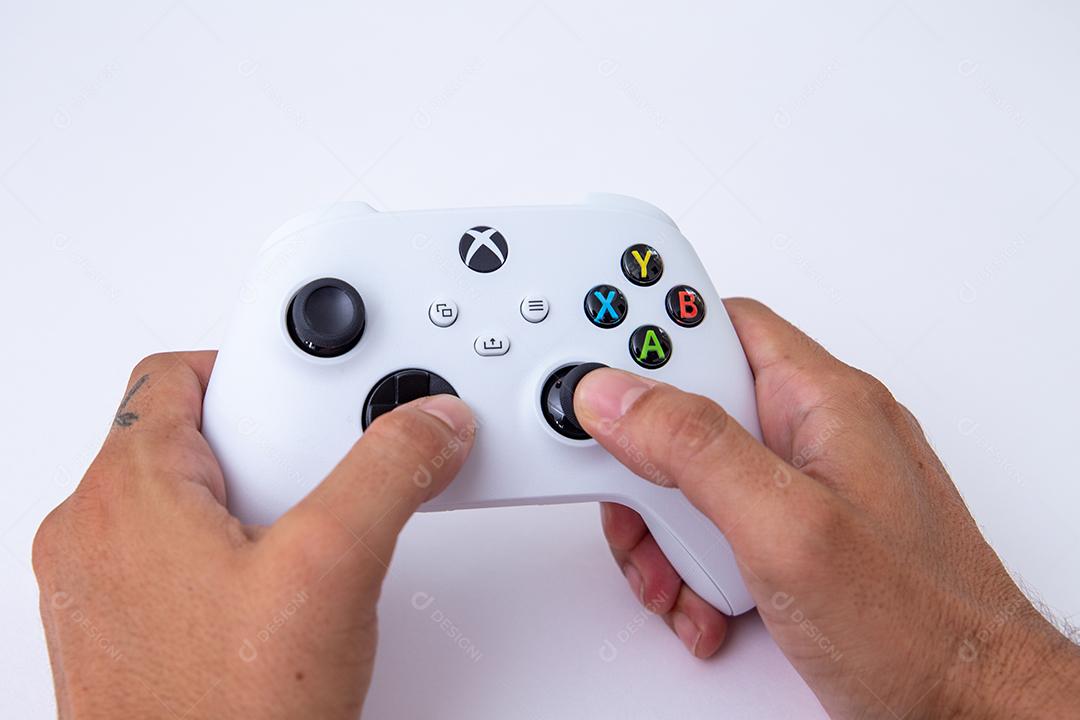 São Paulo, Brasil - 03, 2022: Controlador branco do novo console xbox Series S. Com uma mão operando os botões