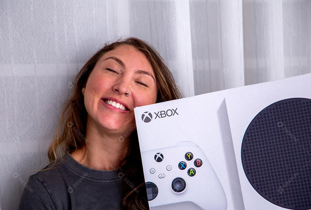 Feliz jovem com um novo console de videogame Xbox Series S.