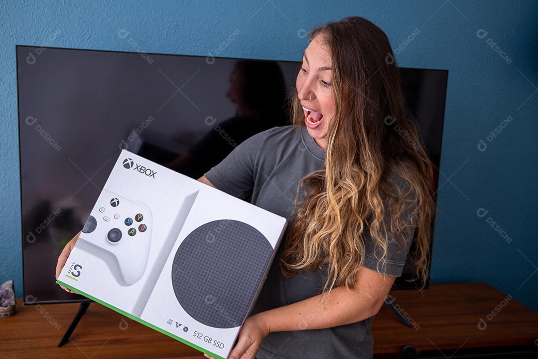 Feliz jovem com um novo console de videogame Xbox Series S.