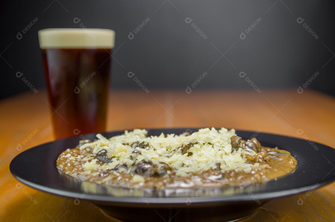 Risoto de funghi saboroso com close-up de carne e queijo.