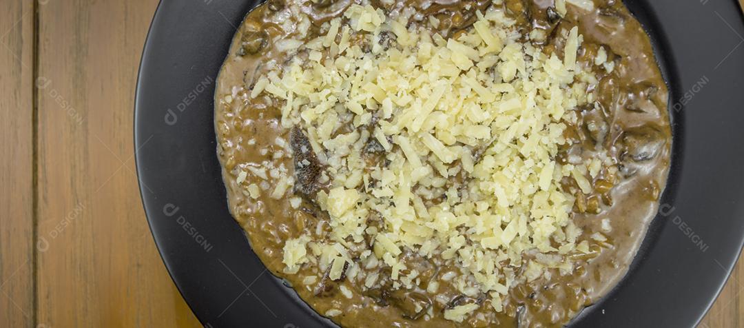 Risoto de funghi saboroso com close-up de carne e queijo.
