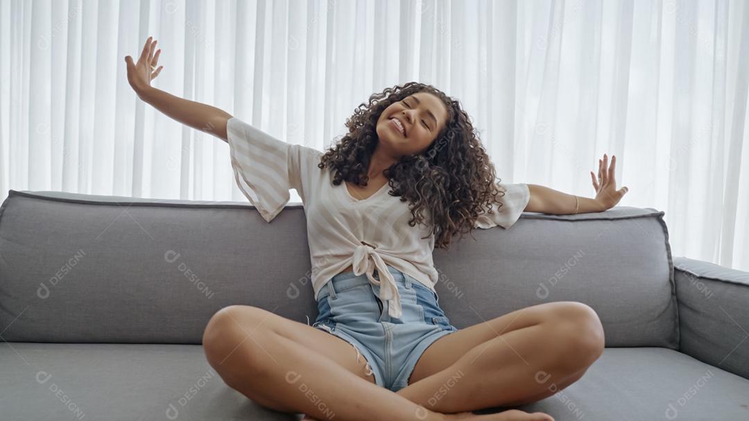 Calma mulher latina relaxando no sofá macio e confortável desfrutando sem estresse no sofá