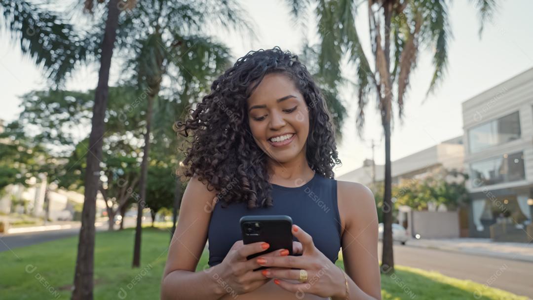 Mulher latina usando smartphone no parque. menina brasileira.