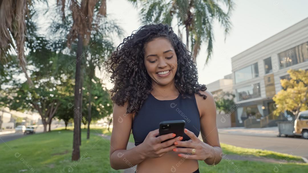 Mulher latina usando smartphone no parque. menina brasileira.