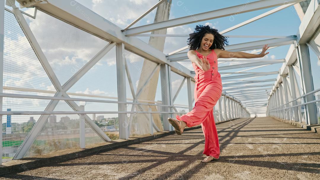 Feliz linda mulher latina andando e dançando ao ar livre. Garota gosta do dia e dança