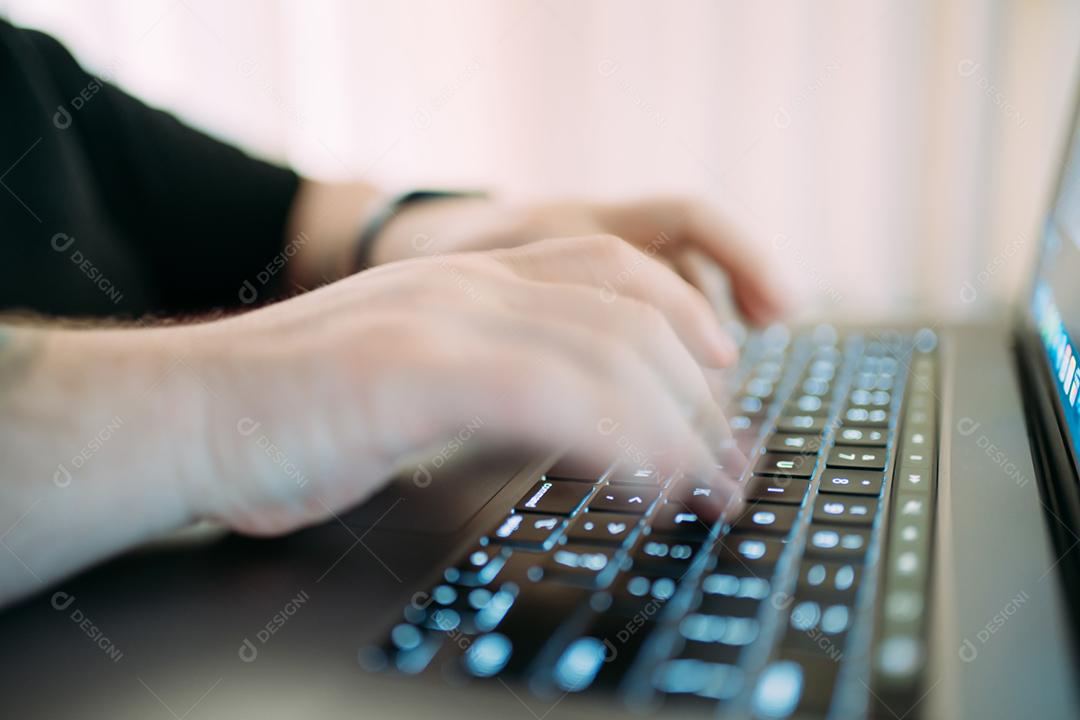 Mãos de um homem usando laptop