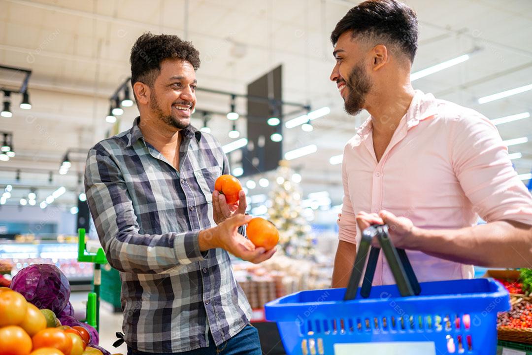 Casal gay latino-americano colhendo tomates no supermercado