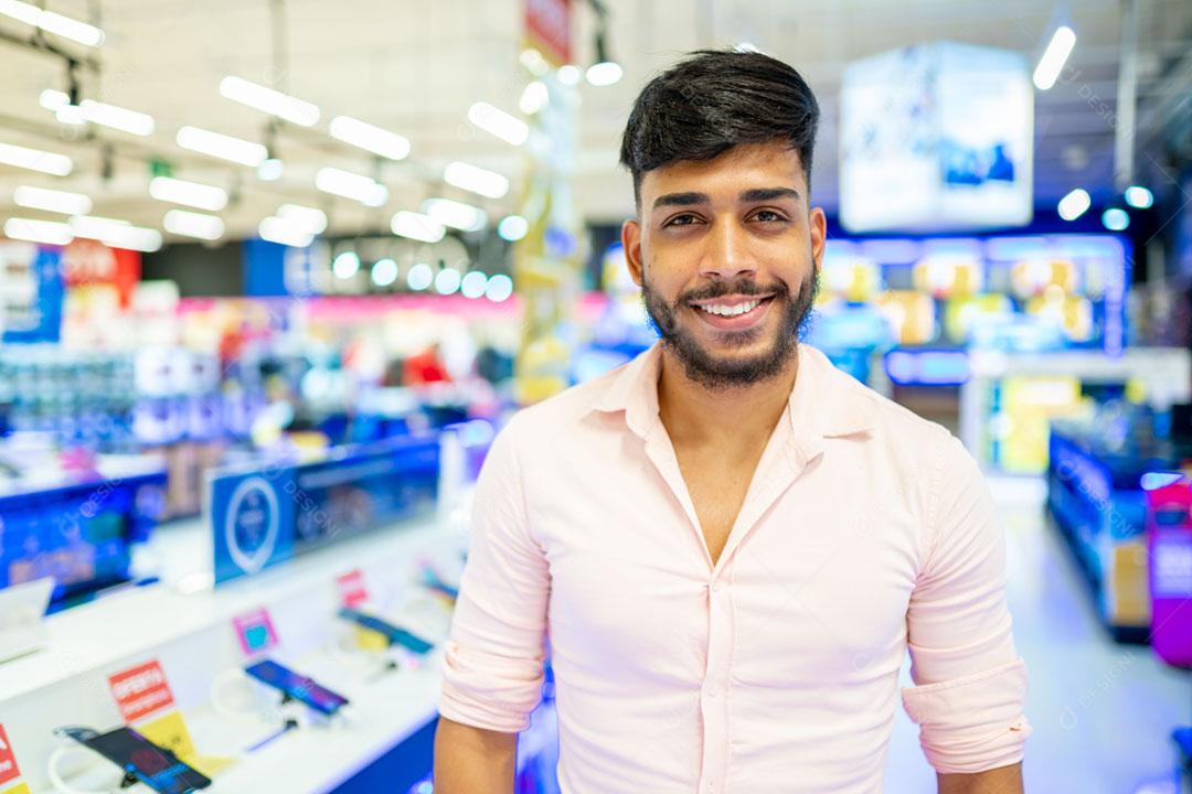 Latino-americano no supermercado. Homem sorridente com os braços e olhando para a câmera