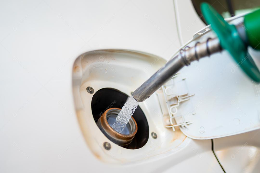 Aproximação do homem bombeando gasolina no carro no posto de gasolina