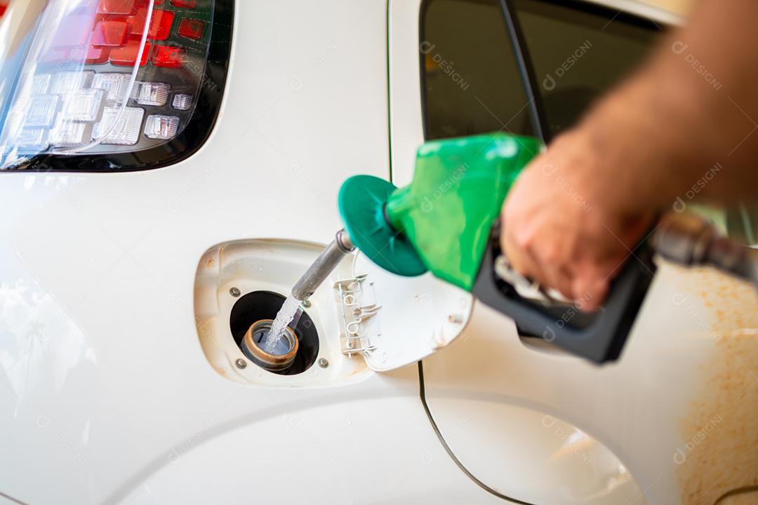 Aproximação do homem bombeando gasolina no carro no posto de gasolina