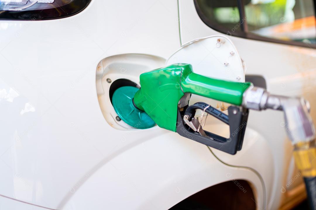 Aproximação do homem bombeando gasolina no carro no posto de gasolina