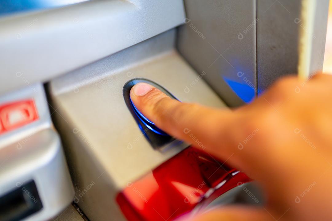 Dedo masculino usando leitor digital no caixa eletrônico