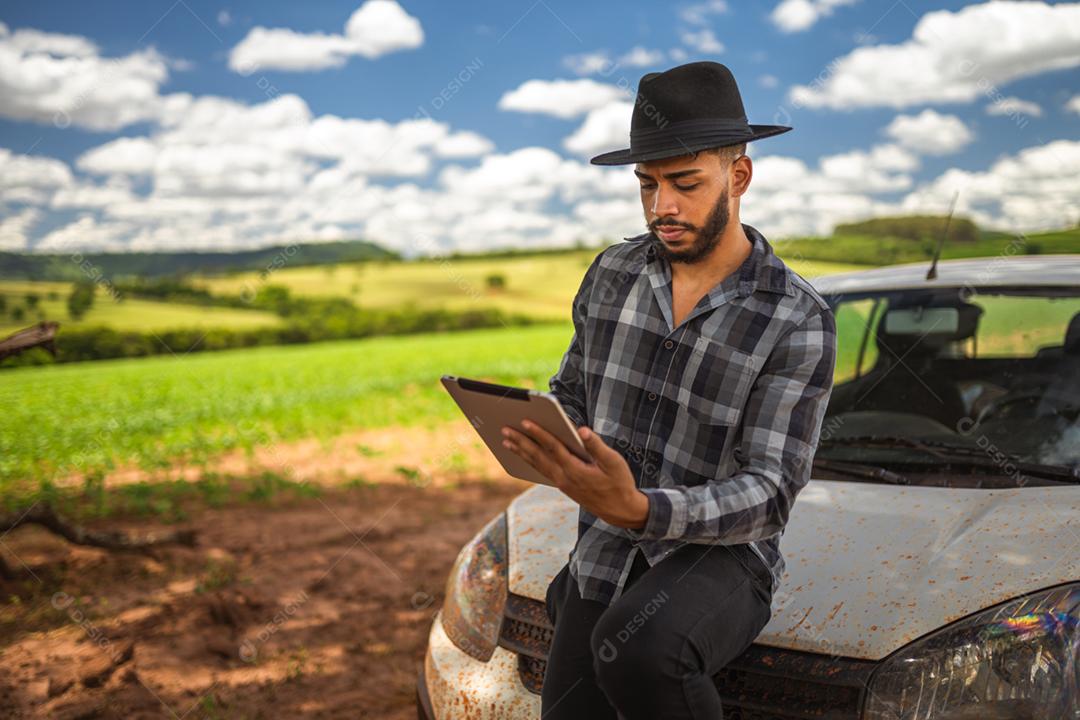 Agricultor latino-americano analisando estatísticas em tablet digital