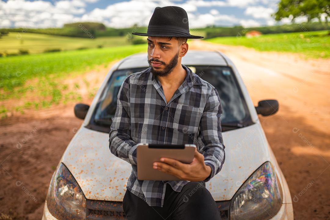 Agricultor latino-americano analisando estatísticas em tablet digital