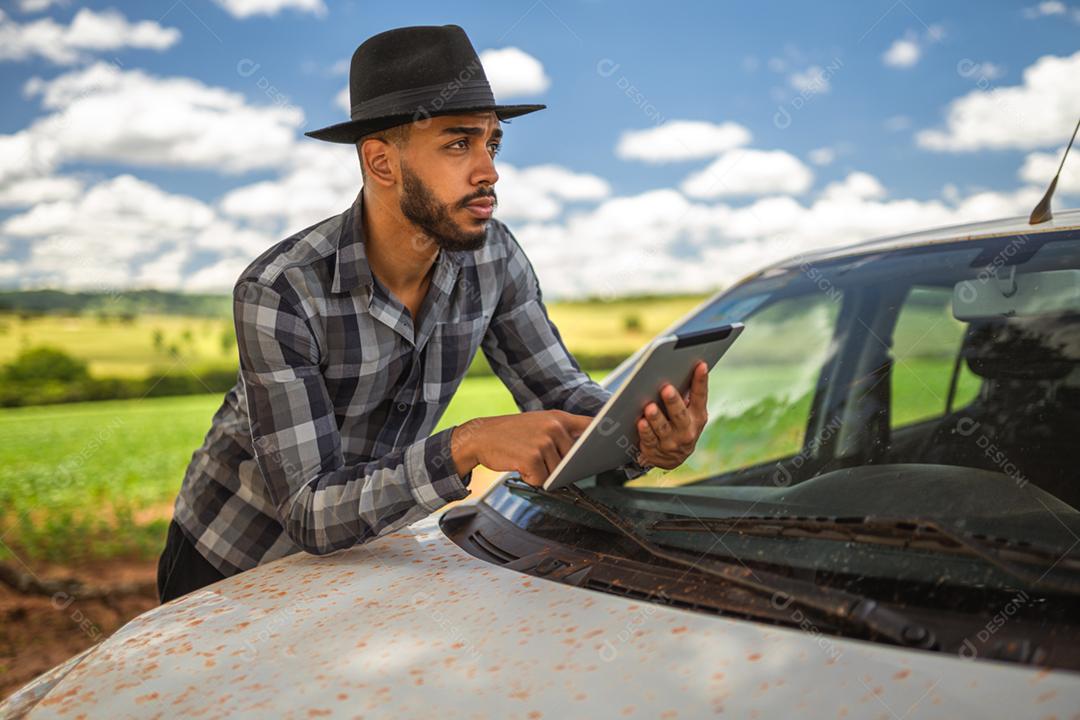 Agricultor latino-americano analisando estatísticas em tablet digital