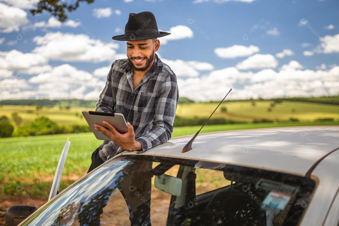 Agricultor latino-americano analisando estatísticas em tablet digital