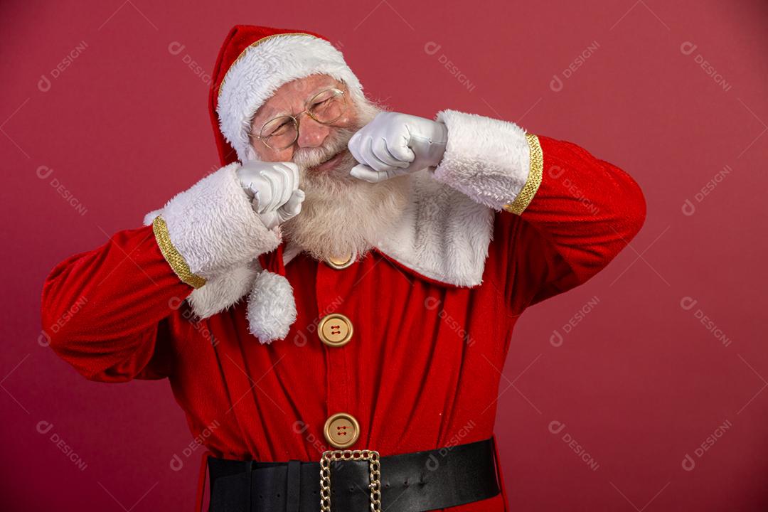 Papai Noel chorando em fundo vermelho, usando óculos e chapéu.