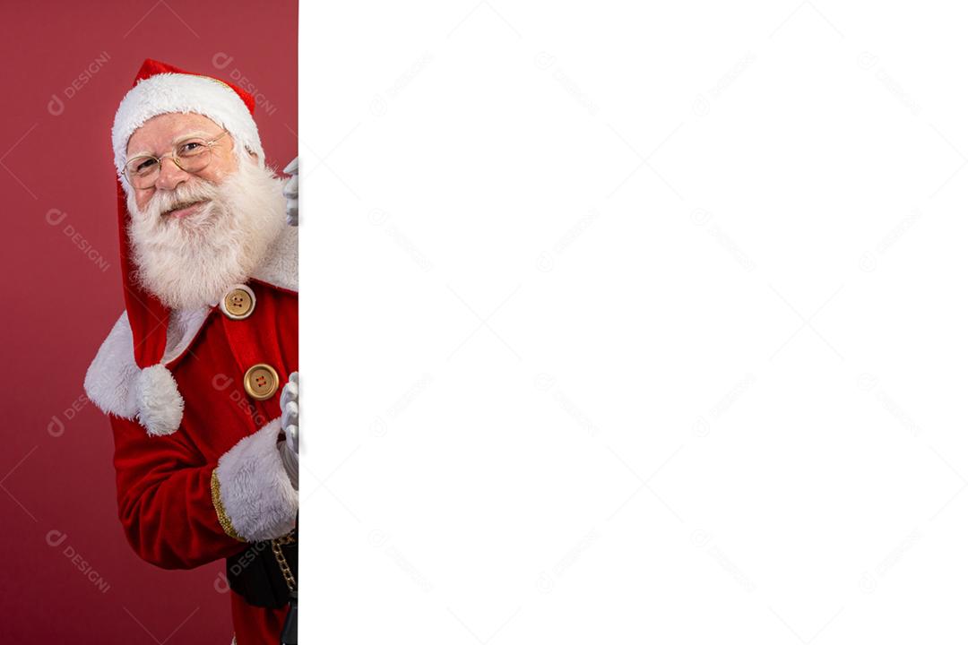 Feliz Papai Noel olhando por trás do sinal em branco isolado em fundo vermelho