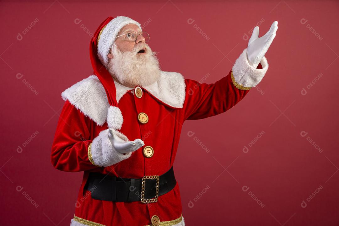 Papai Noel mantendo o dedo indicador pela boca e olhando para a câmera. Shh! Guarde segredo. Silencioso confidencial