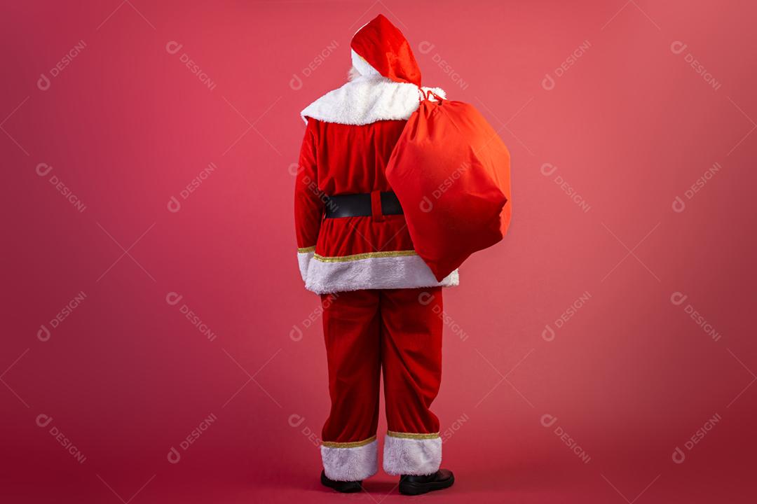 Parte traseira do Papai Noel puxando um enorme saco de presentes em fundo vermelho  Arte da bandeira.