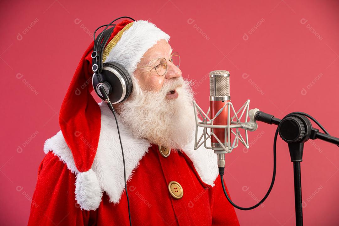 Papai Noel cantando ou falando em um microfone de estúdio. Feliz Natal. Locutor de rádio. Locutor. Promoção