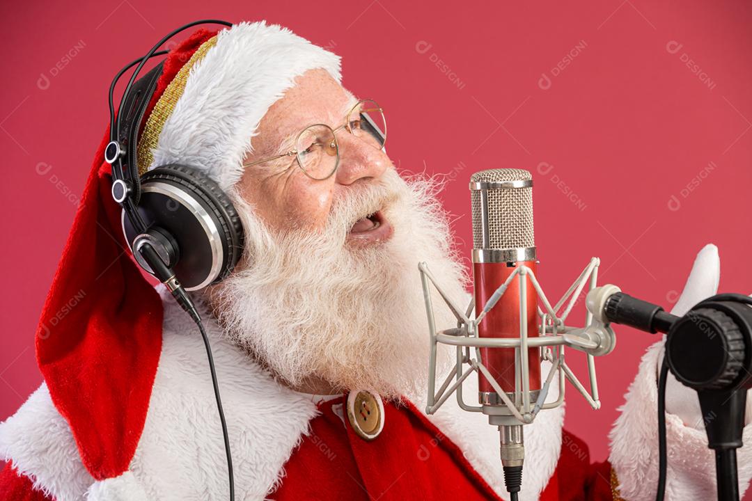Papai Noel cantando ou falando em um microfone de estúdio. Feliz Natal. Locutor de rádio. Locutor. Promoção