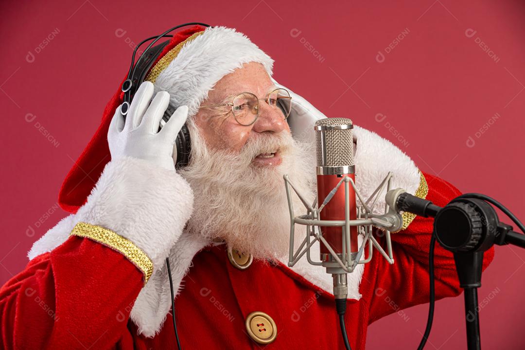 Papai Noel cantando ou falando em um microfone de estúdio. Feliz Natal. Locutor de rádio. Locutor. Promoção