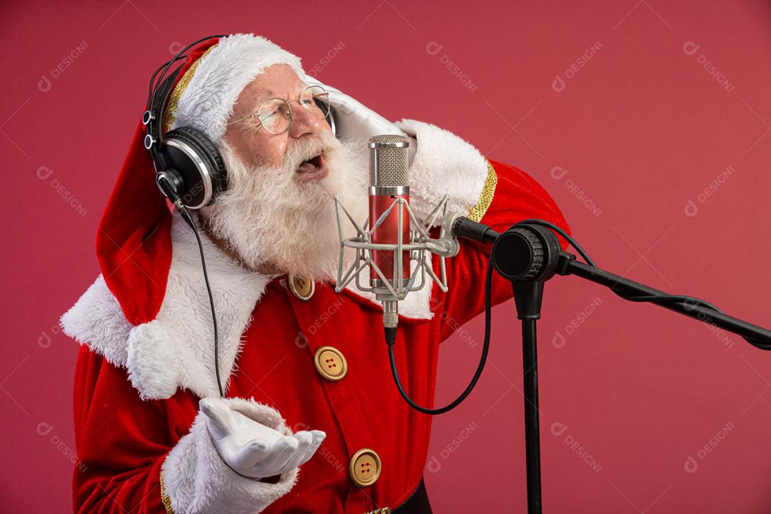 Papai Noel cantando ou falando em um microfone de estúdio. Feliz Natal. Locutor de rádio. Locutor. Promoção