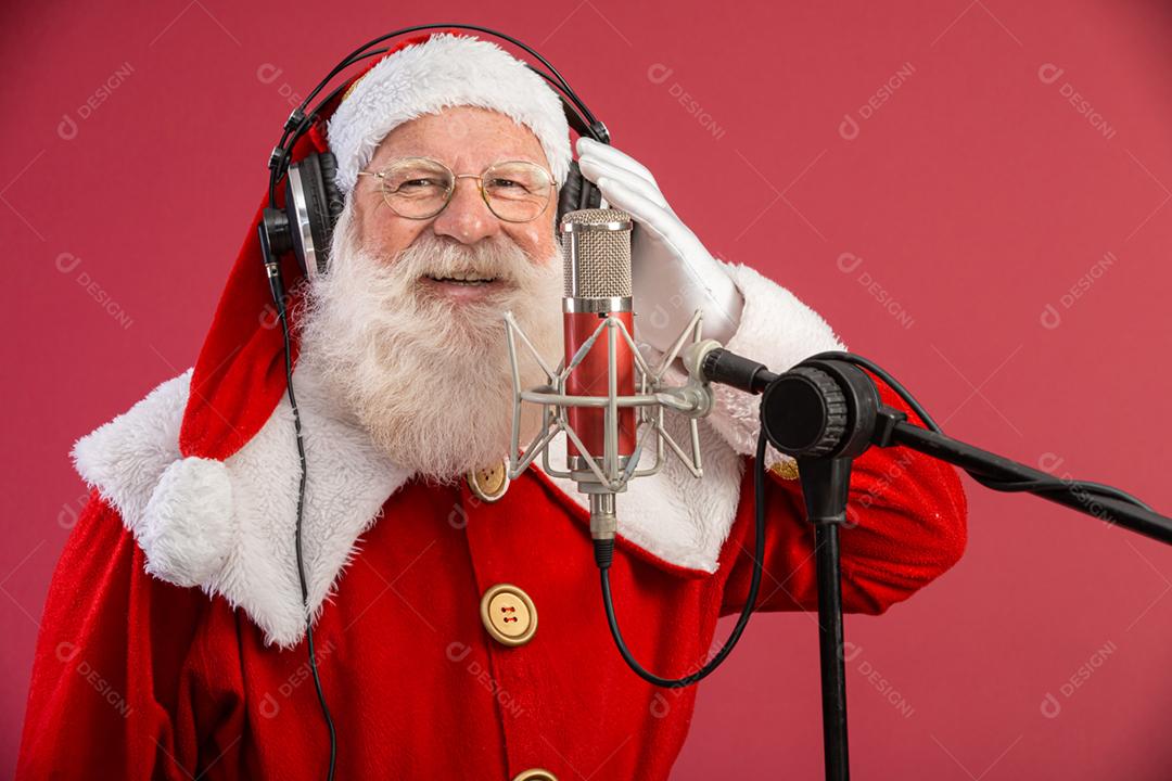 Papai Noel cantando ou falando em um microfone de estúdio. Feliz Natal. Locutor de rádio. Locutor. Promoção
