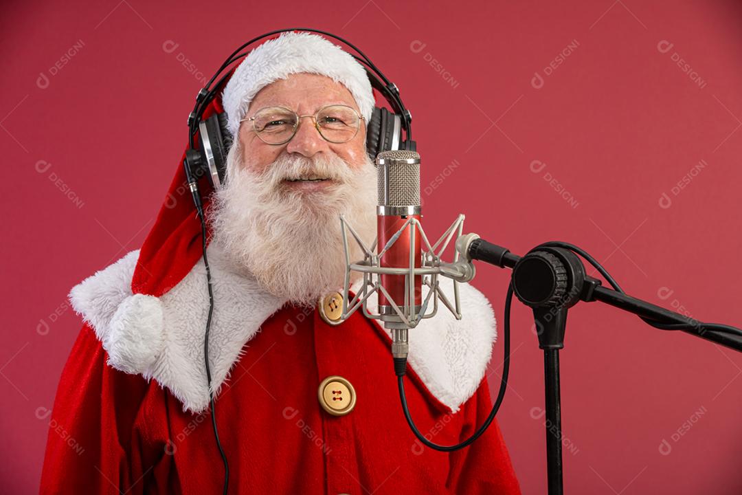 Papai Noel cantando ou falando em um microfone de estúdio. Feliz Natal. Locutor de rádio. Locutor. Promoção