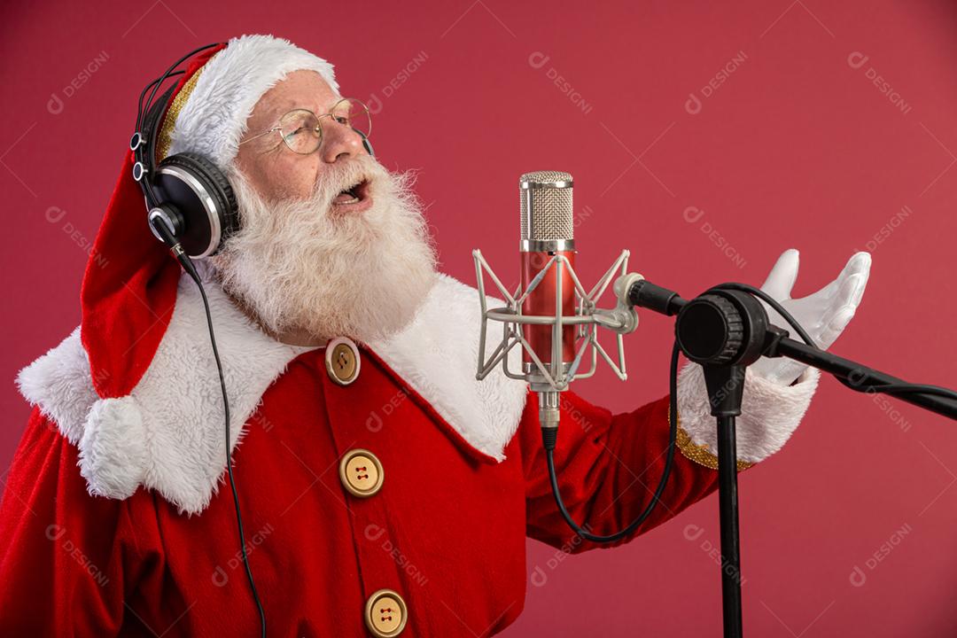 Papai Noel cantando ou falando em um microfone de estúdio. Feliz Natal. Locutor de rádio. Locutor. Promoção