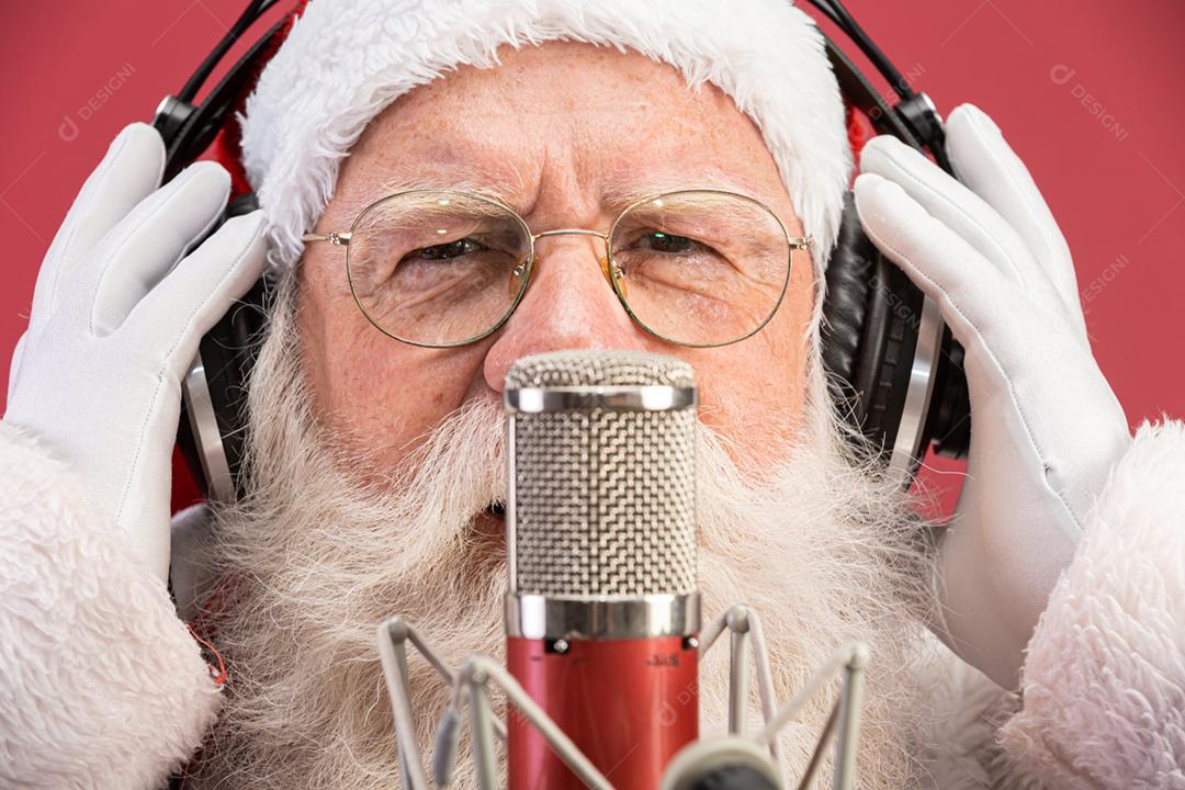 Papai Noel cantando ou falando em um microfone de estúdio. Feliz Natal. Locutor de rádio. Locutor. Promoção