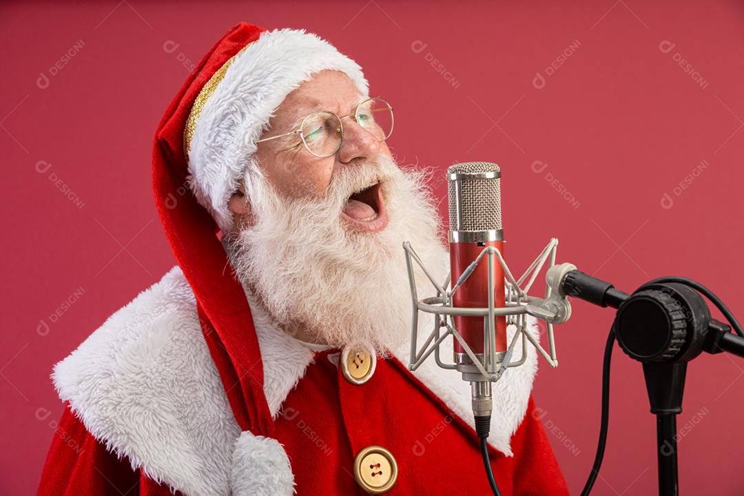 Papai Noel cantando ou falando em um microfone de estúdio. Feliz Natal. Locutor de rádio. Locutor. Promoção