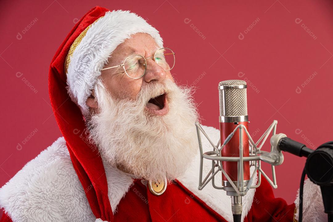 Papai Noel cantando ou falando em um microfone de estúdio. Feliz Natal. Locutor de rádio. Locutor. Promoção