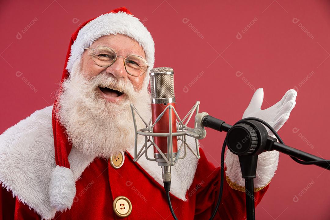 Papai Noel cantando ou falando em um microfone de estúdio. Feliz Natal. Locutor de rádio. Locutor. Promoção