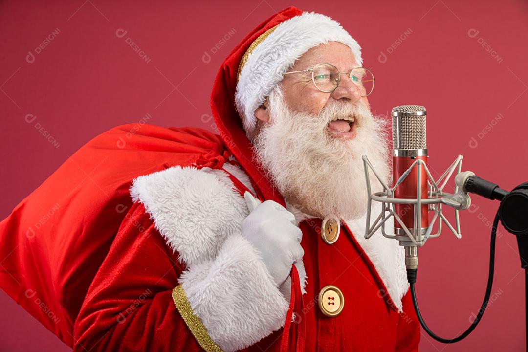 Papai Noel cantando ou falando em um microfone de estúdio. Feliz Natal. Locutor de rádio. Locutor. Promoção