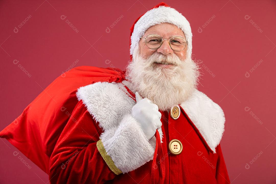 Papai Noel puxando um enorme saco de presentes em fundo vermelhovArte da bandeira.