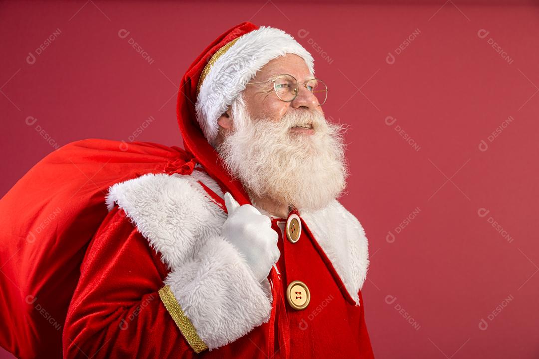 Papai Noel puxando um enorme saco de presentes em fundo vermelhovArte da bandeira.