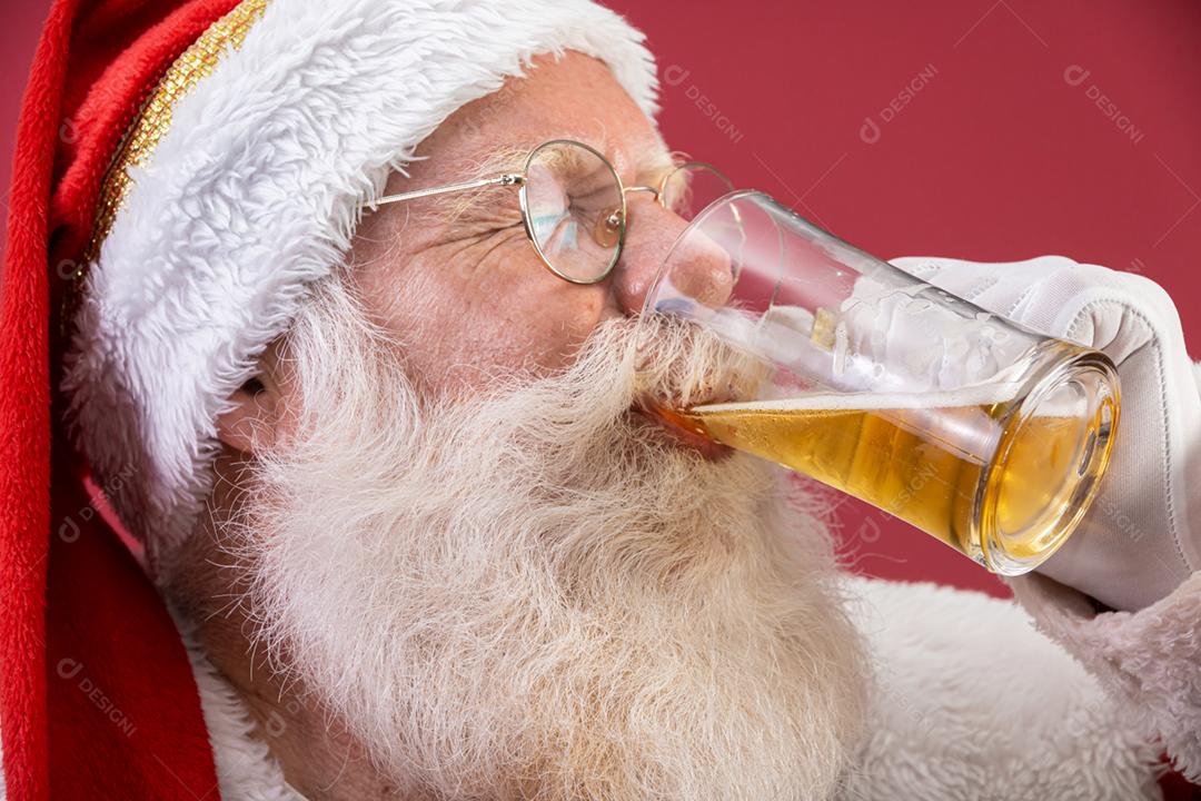 Papai Noel bebendo um copo de cerveja. Tempo de descanso. Bebida alcoólica nos feriados