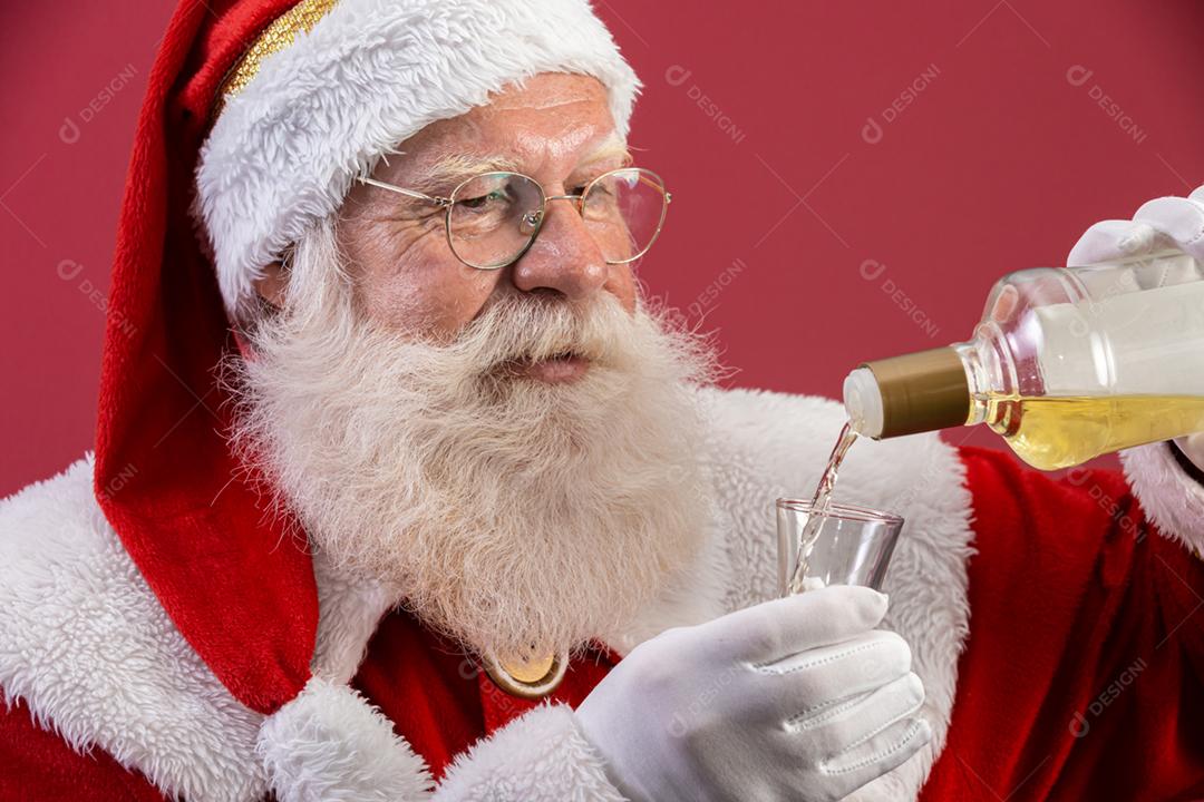 Papai Noel bebendo uma bebida brasileira chamada Cachaça. Tempo de descanso. Bebida alcoólica