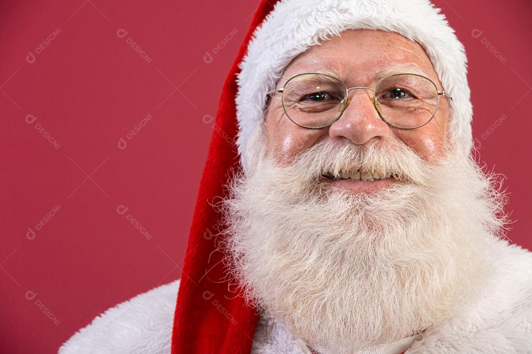 Verdadeiro Papai Noel com um fundo vermelho, usando óculos, luvas e uma câmera com aparência