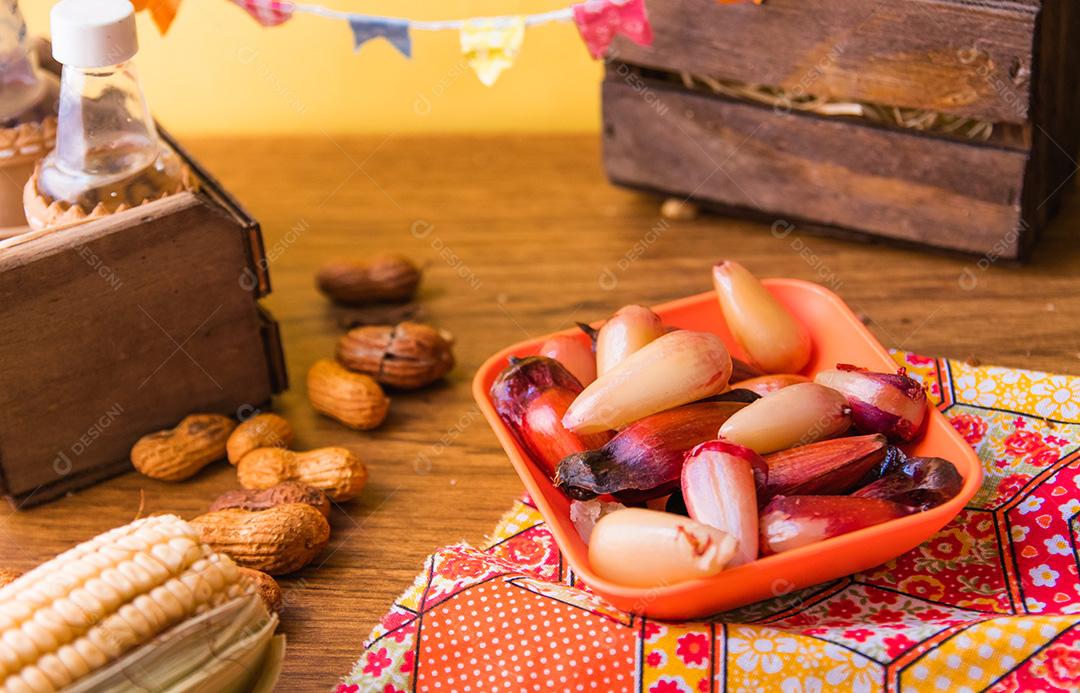 Pinhões cozidos, sem casca, típicos da Festa Junina. Comida tradicional do Brasil, doce de Festa Junina. Arraial Fundo De Madeira Rústico.