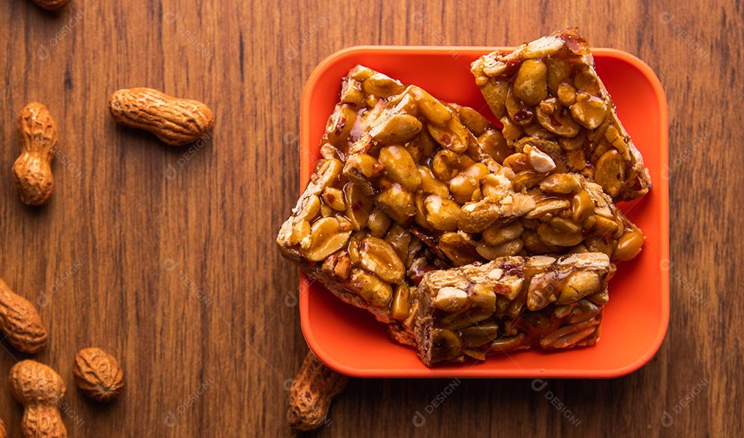 Pe de moleque, typical Brazilian peanut candy on a wooden table.
