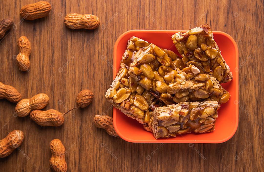 Pe de moleque, doce de amendoim típico brasileiro sobre mesa de madeira.