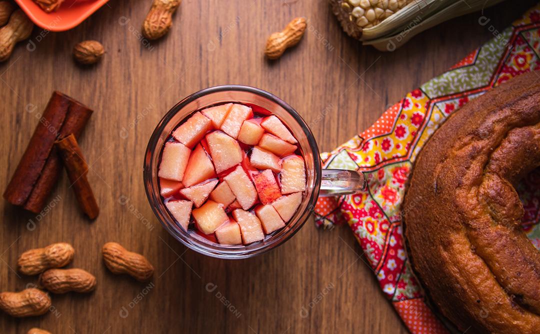 Vinho quente do Brasil com pedaços de maçã, típico da Festa Junina. Comida tradicional do Brasil, o doce da Festa Junina. Fundo de madeira rústico