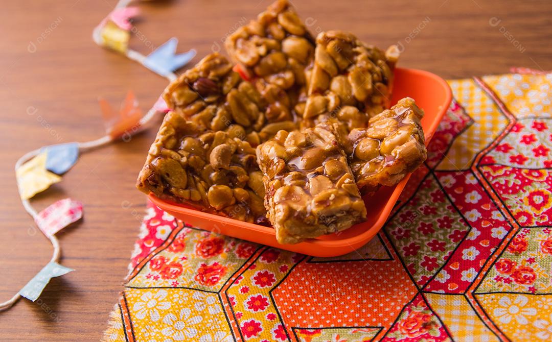 Pe de moleque, doce de amendoim típico brasileiro sobre mesa de madeira.