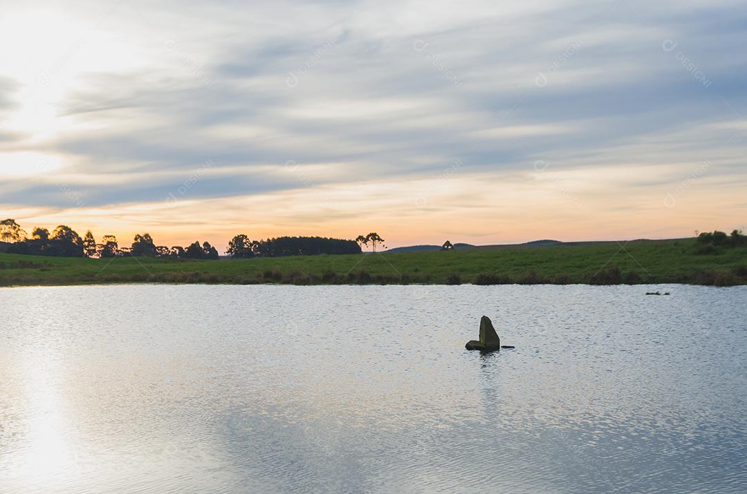 Linda paisagem no campo com rio, tardezinha com céu nublado.