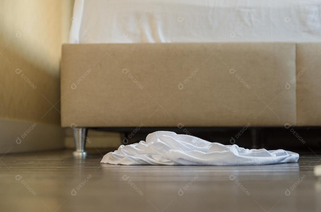 Roupas deitadas no chão do quarto.