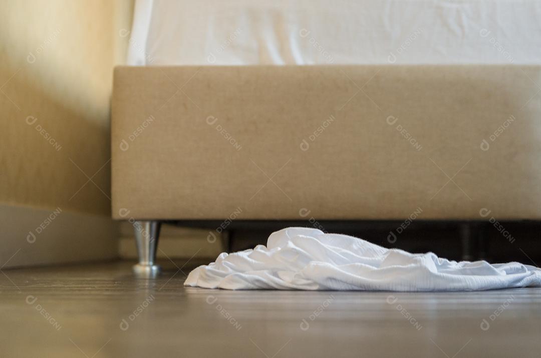 Roupas deitadas no chão do quarto.