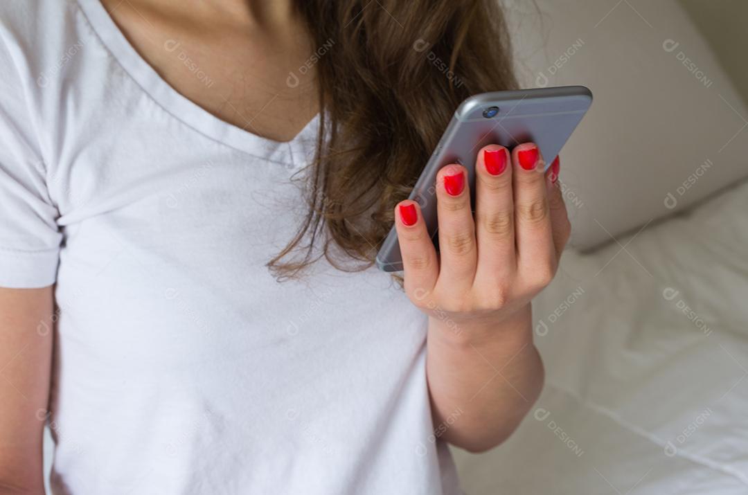 Mulher segurando smartphone sobre fundo branco